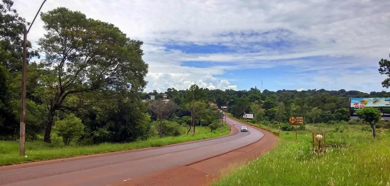 Route PY06 passing through the green outskirts of Hohenau, one of the colony towns among the cities in Paraguay's Itapúa department