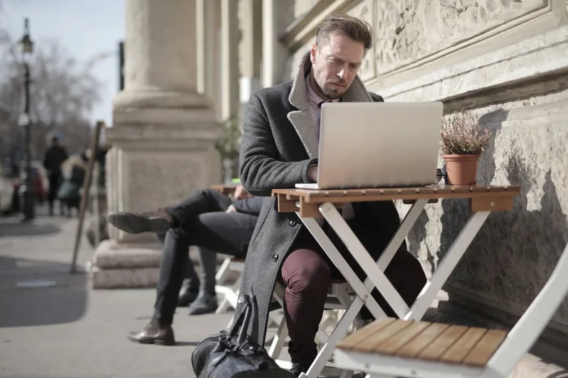 A freelancer working on a laptop abroad, weighing the best countries for freelancers